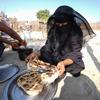 也门妇女在临时住所外烤面包。