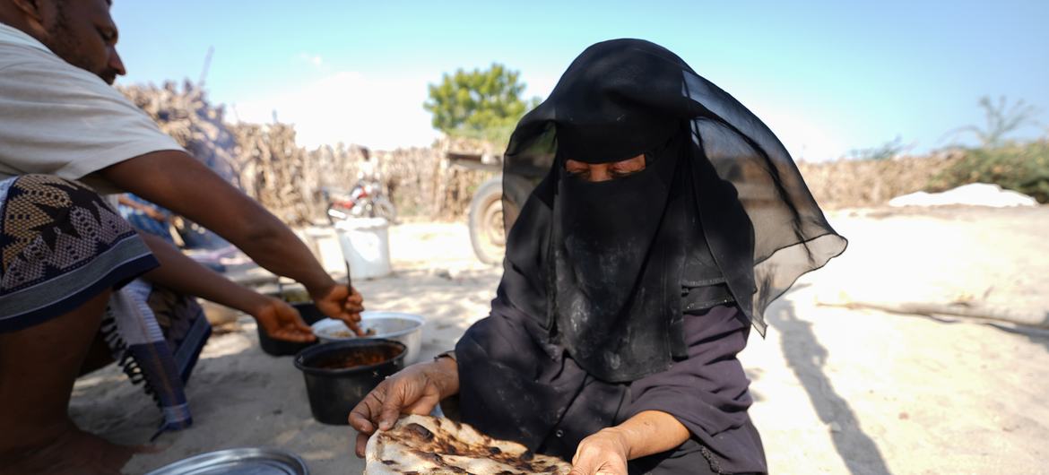 A woman baking bread at her shelter in Khanfar District, Yemen.