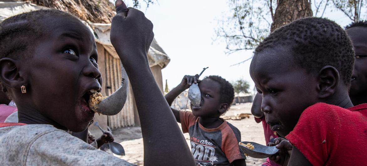 أطفال في مقاطعة فانجاك بولاية جونقلي يأكلون وجبة مطبوخة من الذرة البيضاء. حيث يوفر برنامج الأغذية العالمي حصصا غذائية للأسر التي تعاني من انعدام الأمن الغذائي وتحتوي على الذرة البيضاء والزيت والملح والبازلاء. جنوب السودان 20 يناير 2022.