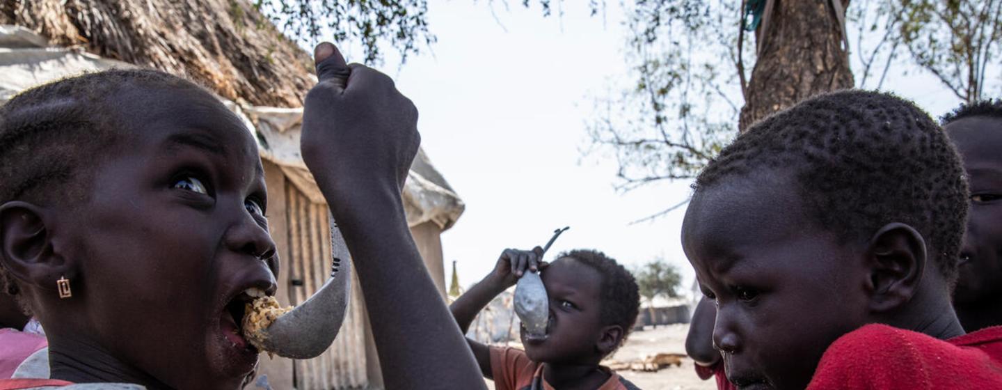 Niños del condado de Fangak, en el estado de Jonglei, comen una comida cocinada a base de sorgo. El PMA suministra raciones de alimentos a familias en situación de inseguridad alimentaria con sorgo, aceite, sal, guisantes y maíz, Sudán del Sur 20 de enero