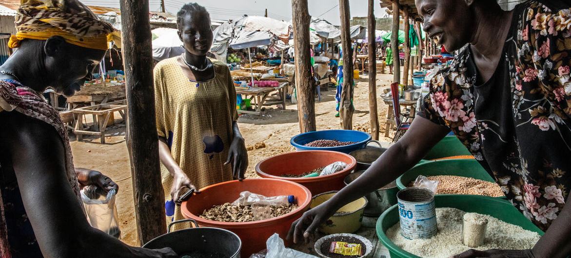 سيدة تشتري الطعام من السوق في بور (ولاية جونقلي)، حيث يوفر برنامج الأغذية العالمي النقود التي يمكن للناس استخدامها لشراء الطعام في العديد من المتاجر في السوق جنوب السودان، بور، ولاية جونقلي، 23 آذار/مارس 2022