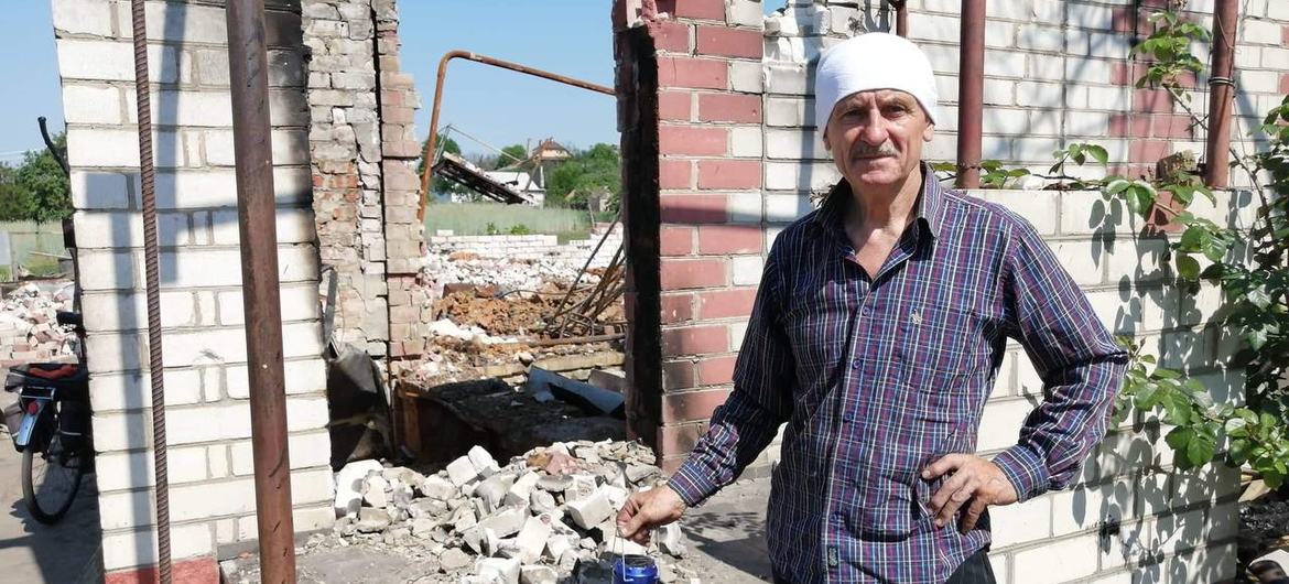乌克兰切尔尼戈夫地区一位居民站在他被摧毁的房屋废墟旁。