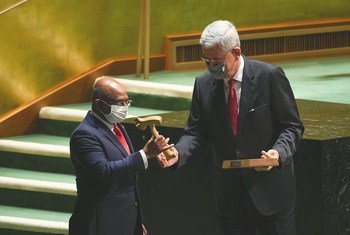 Председатель 75-й сессии Генассамблеи ООН Волкан Бозкыр передает молоток председателя Абдулле Шахиду, Председателю 76-й сессии Генассамблеи ООН. 