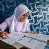 इंडोनेशिया के मध्य जावा प्रांत में एक 14 वर्षीय लड़की घर पर एक स्कूल असाइनमेंट पर काम करती है.