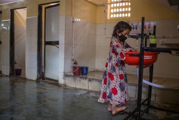 Una niña se lava las manos en un baño comunitario de Mumbai, India.