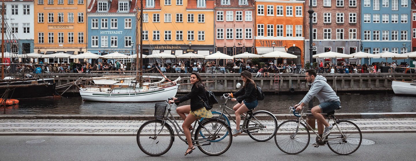 Unos turistas pedalean por los alrededores de Nyhavn, en Copenhague (Dinamarca).