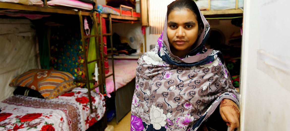 A Bangladeshi garment worker is seen standing in the room she shares with other seven colleagues in a factory dormitory in Jordan.