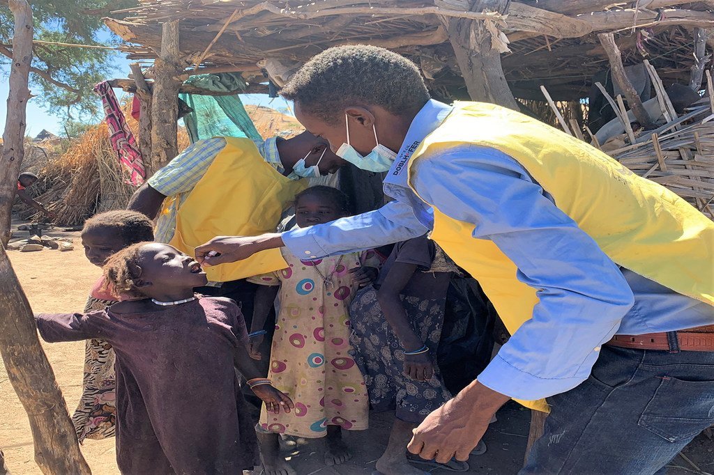 عامل في مجال الصحة في كارا، جنوب جبل مرَّة، يعطي طفلة عمرها 4 سنوات جرعتها من اللقاح ضد شل الأطفال 