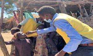 عامل في مجال الصحة في كارا، جنوب جبل مرَّة، يعطي طفلة عمرها 4 سنوات جرعتها من اللقاح ضد شل الأطفال 