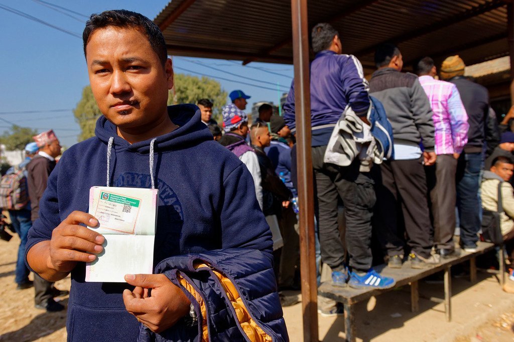Un travailleur du bâtiment népalais reçoit un visa de travail pour l'Arabie saoudite dans un centre de ressources sur les migrations.
