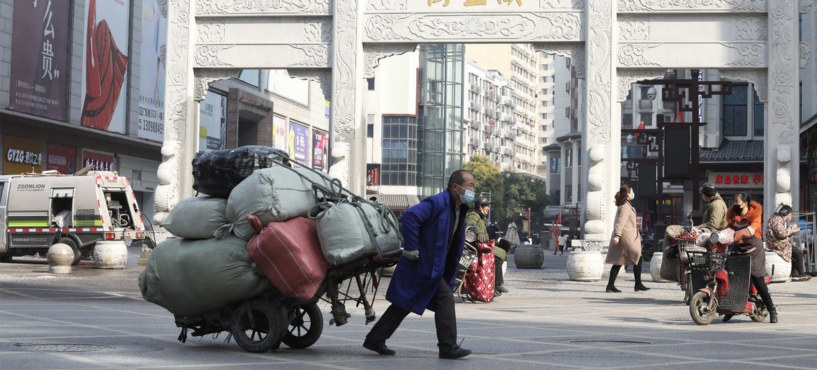 2021年1月15日，一名商贩拉着货物经过武汉汉正街口。