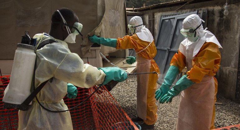 أحد العاملين الصحيين في غينيا يقوم بتعقيم نفسه خلال تفشي إيبولا في غرب أفريقيا عام 2015.