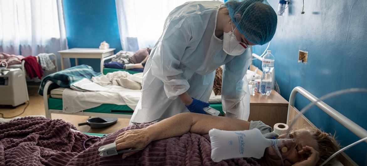 A health worker checks a COVID patient's condition at a hospital in Kharkiv, Ukraine.