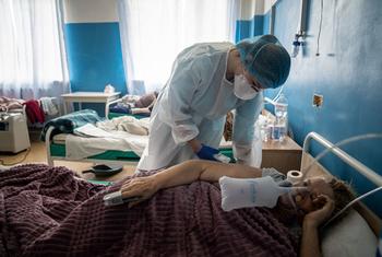 A health worker checks a COVID patient's condition at a hospital in Kharkiv, Ukraine.