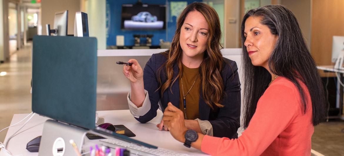 Two women working on their laptops.