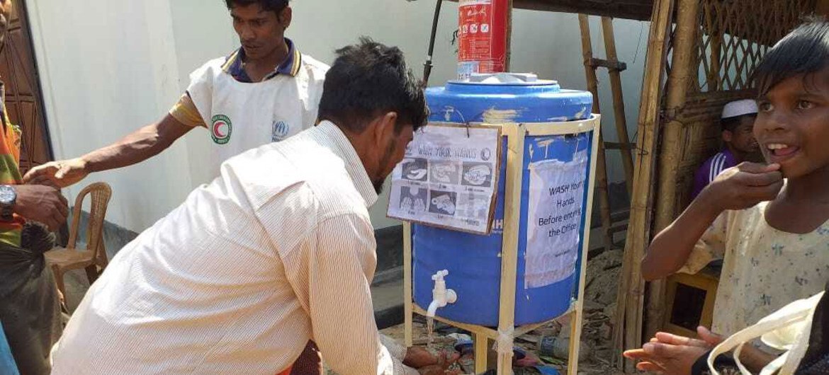 Rohingya refugees use a handwashing station, installed to help combat the spread of COVID-19 at a settlement in Cox's Bazar, Bangladesh.