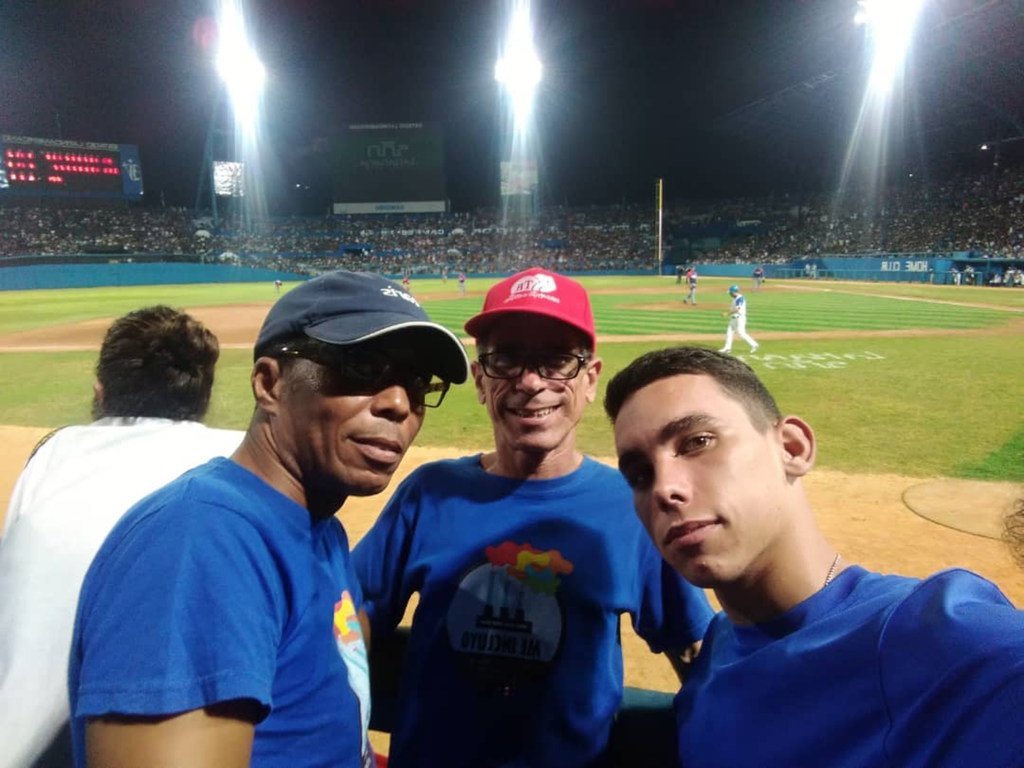 Francisco Rodríguez Cruz, Paquito (centro), con su hijo y su pareja en un juego de beisbol en Cuba.