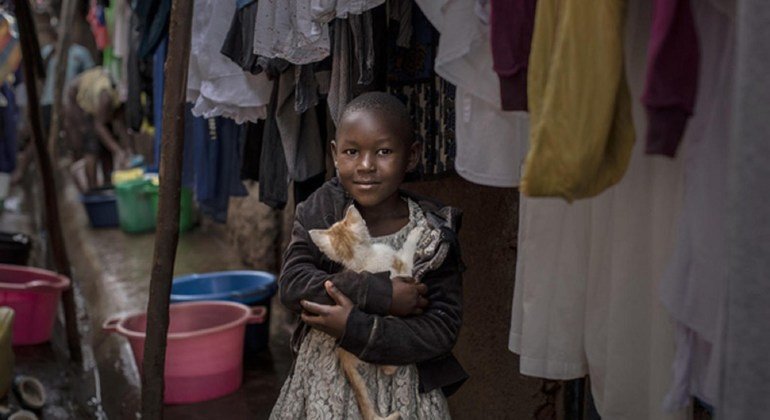 Jennifer Atieno mwenye umri wa miaka 7 akiwa amekumbatia paka wake karibu na makazi duni ya Kibera jijini Nairobi, Kenya.