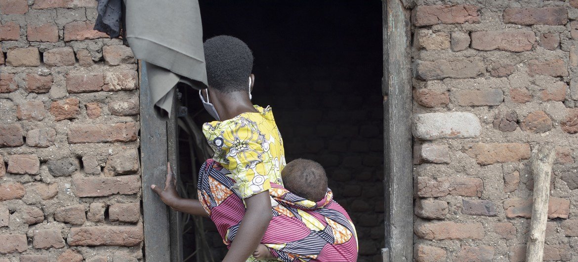 Une jeune fille de 14 ans porte son bébé au domicile de ses parents à Kasese, dans l'ouest de l'Ouganda.