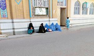 अफ़ग़ानिस्तान के हेरात शहर में एक मस्जिद के सामने भिक्षा का इन्तज़ार करती महिलाएँ और बच्चे.