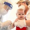 Un bebé recibe una vacuna en Kosovo durante la pandemia de COVID-19.