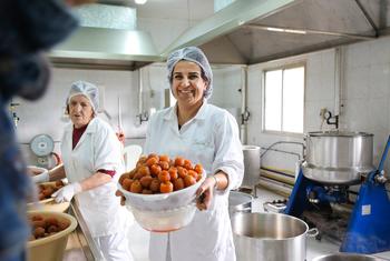Samira Zoughaib Akiki, présidente de la coopérative Al Atayeb, tenant un panier rempli de marmelade.