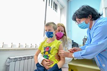 在马其顿斯科普里的一家诊所，一名 7 岁儿童在接种后续白喉、破伤风和百日咳三联疫苗。