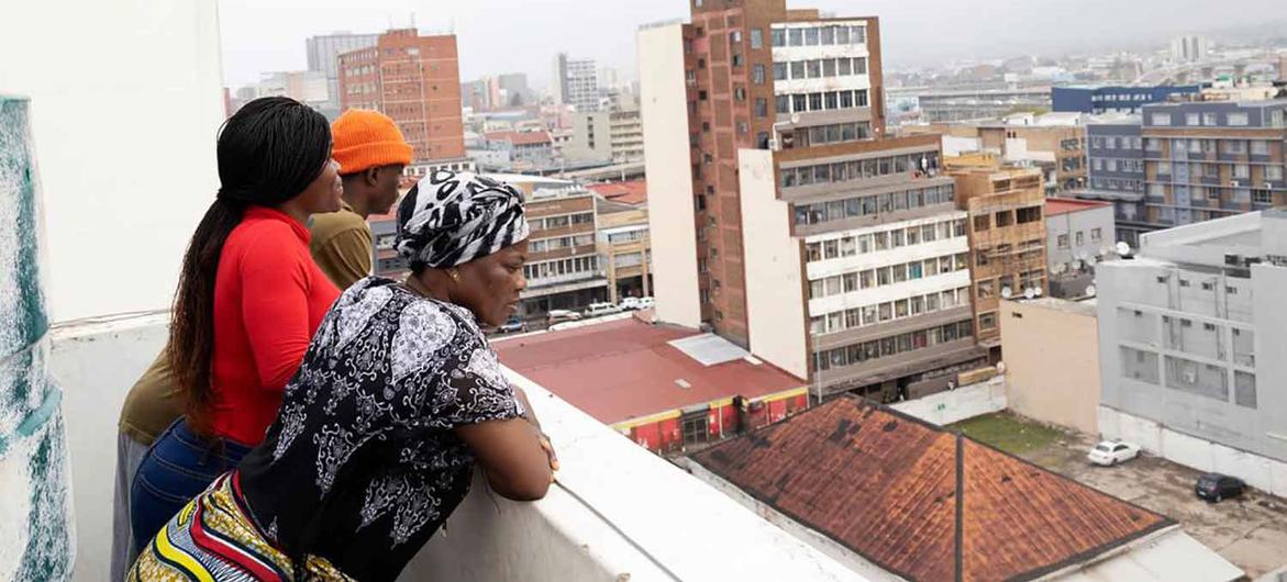 A family look out over Durban in South Africa from their apartment building. They fled their home in the Democratic Republic of the Congo due to conflict more than fifteen years ago. (Dec 2021)