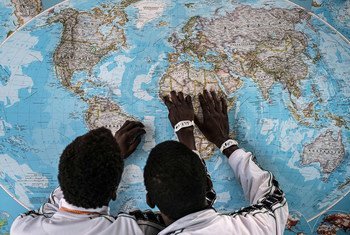  مهاجران يافعان من غامبيا  (غير مصحوبين يأحد الوالدين) يلقيان نظرة على الخريطة بعد عبورهما إلى إيطاليا في عام 2016. (ملف)