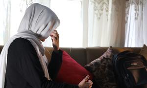 Une fille afghane pose le visage caché à l'intérieur d'une maison de Kaboul, la capitale de l'Afghanistan.