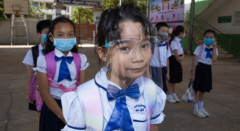 Alunos de uma escola Primária no Camboja, durante o segundo dia de reabertura da escola. Todos os alunos, professores e o diretor da escola usam máscaras, mantêm o distanciamento físico e seguem outras práticas.