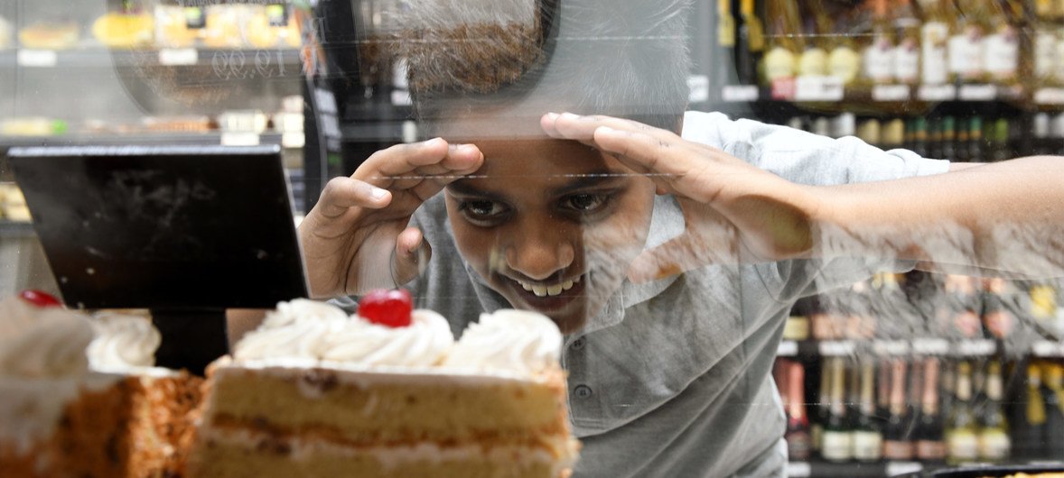 南非比勒陀利亚，10岁的那伊多望着超市糕点柜台里诱人的蛋糕。