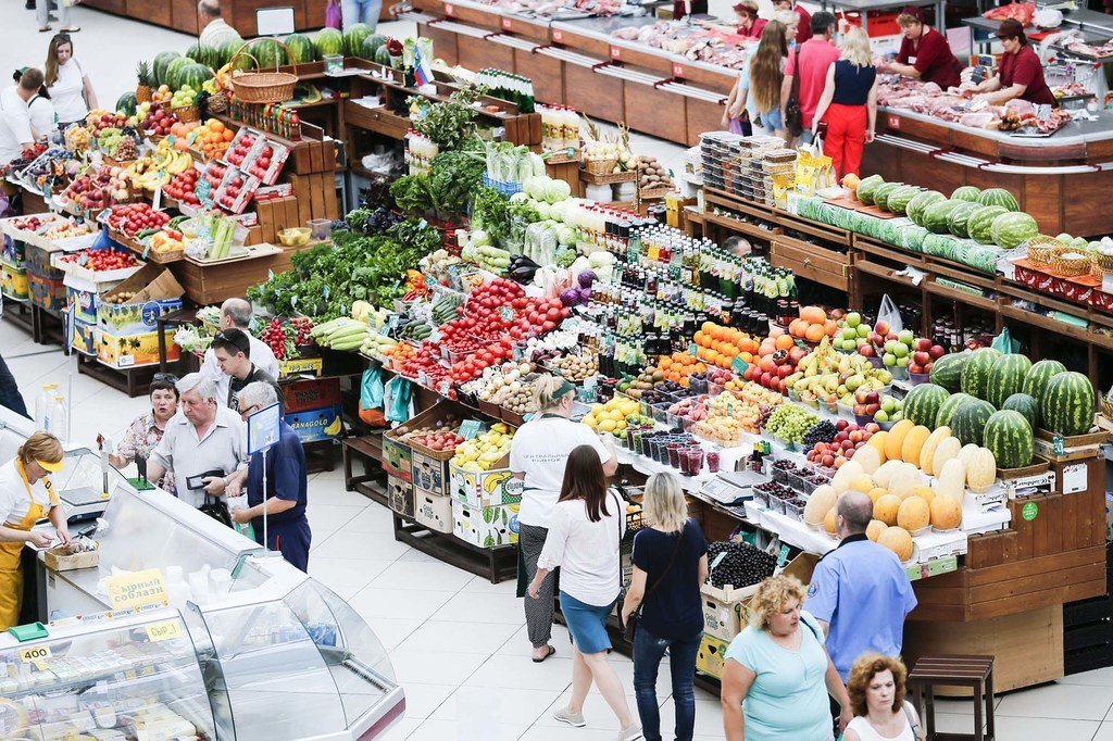 2019年7月25日，人们在俄罗斯沃罗涅日中央市场的一家杂货店购买水果和蔬菜。