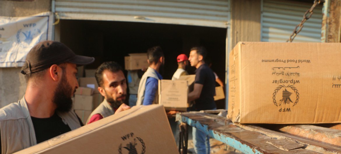 Des travailleurs humanitaires dans le gouvernorat d'Al-Hasakeh, en Syrie, déchargent de l'aide alimentaire fournie par le PAM. (13 octobre 2019)