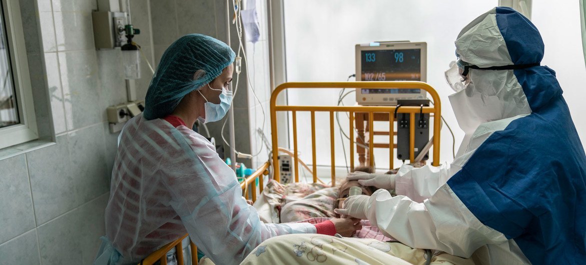 乌克兰切尔诺夫茨西部地区，一位母亲和医生在重症监护室照顾一名罹患新冠的年轻女孩。