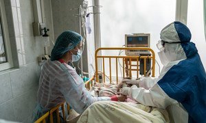 乌克兰切尔诺夫茨西部地区，一位母亲和医生在重症监护室照顾一名罹患新冠的年轻女孩。