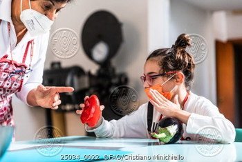 09 October 2021, Rome, Italy - Demetra, a disabled child, manipulates vegetables to recognize them during a cooking class with cook Naheda in the church of Santa Maria Regina Pacis.
