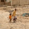 أب وطفله يسيران في مخيم للنازحين بالقرب من مدينة مأرب في اليمن.