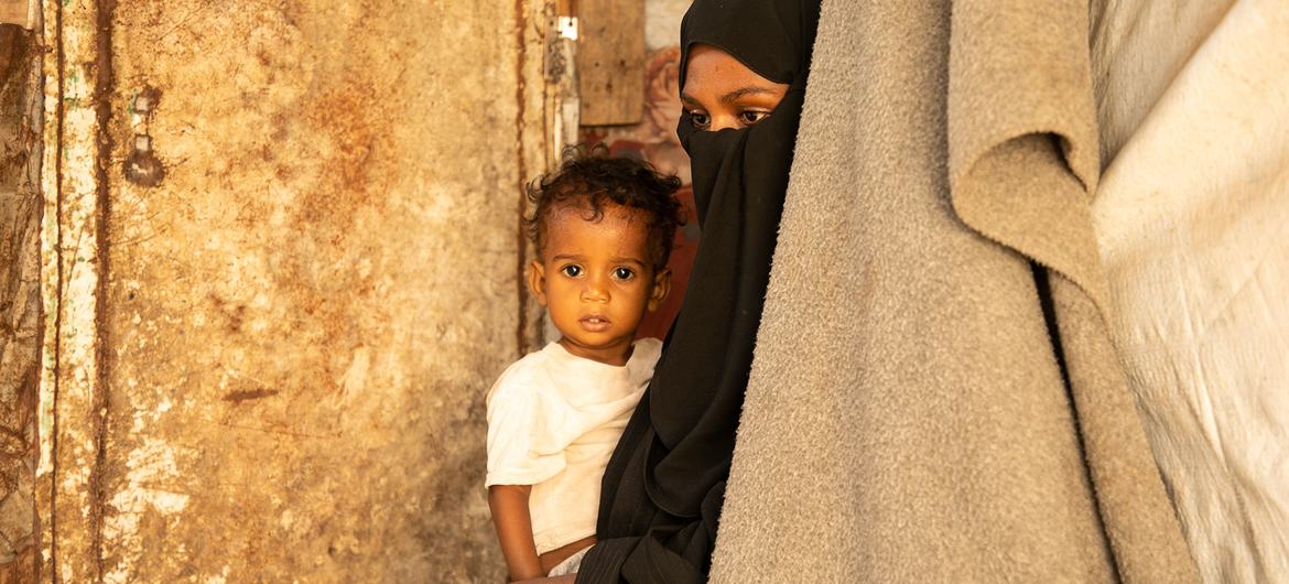 Mulher e criança deslocadas vivendo em uma escola abandonada em Aden, Iêmen