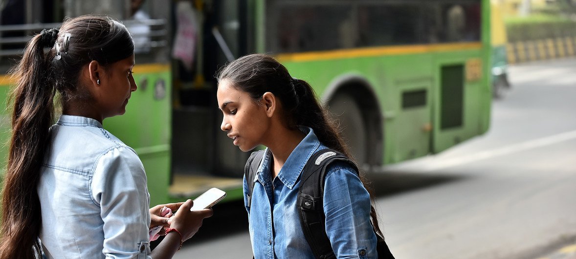 印度新德里，两名女童正在使用智能手机。