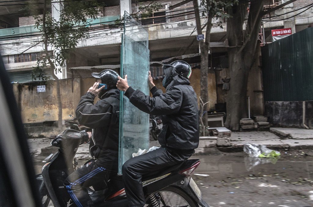 越南两名男子通过小型摩托车运送玻璃面板。 （资料）
