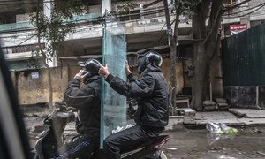 Two men transport glass panels via motor scooter in Vietnam. (file)