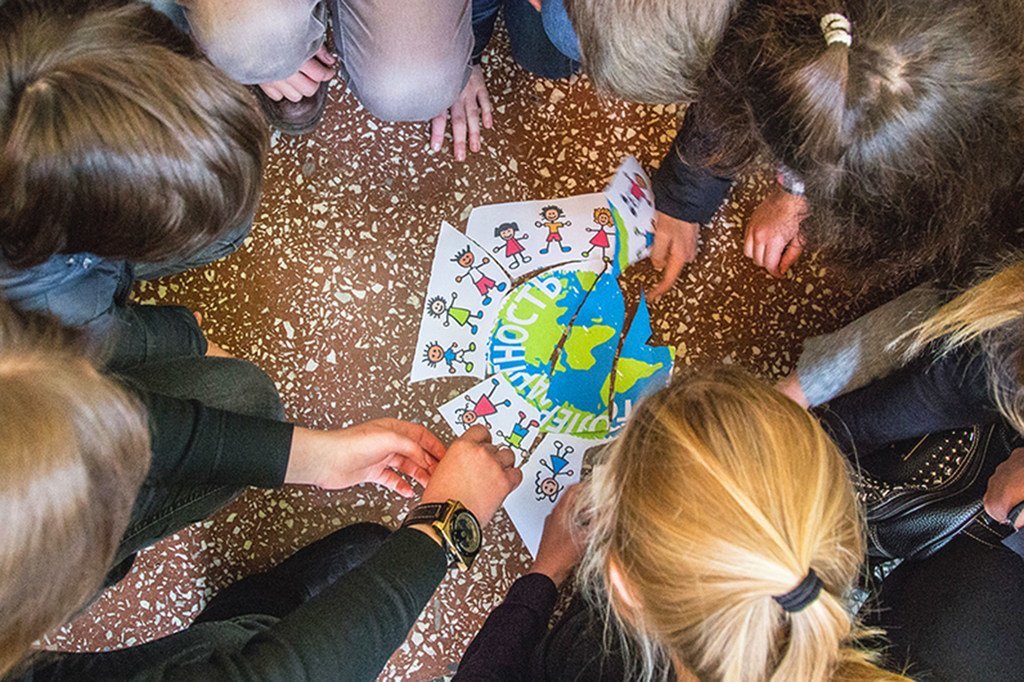 Des enfants ukrainiens jouent avec une affiche des ODD illustrant des enfants de différentes races à travers le monde.