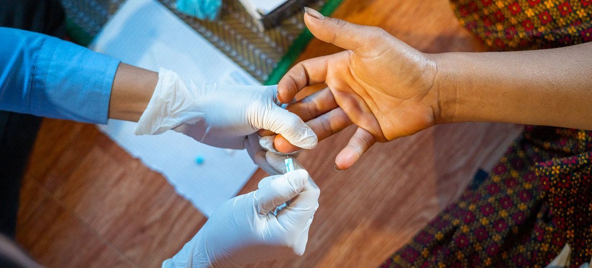 A dual HIV/syphilis rapid diagnostic test is administered on a pregnant woman in Cambodia.