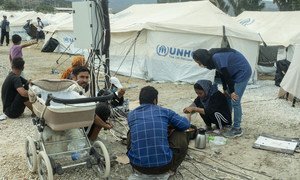 Refugees cook food and charge mobile phones at a temporary site after a fire destroyed the main camp at Moria, in Lesvos island, Greece.
