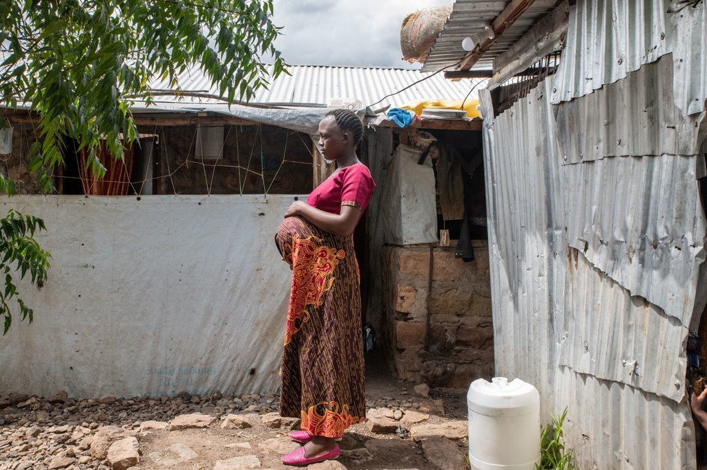 A 23-year-old pregnant Burundian refugee, stands outside her home in Kalobeyei village in Kenya.