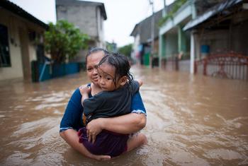 Une femme porte sa fille pendant les inondations à Jakarta, en Indonésie.