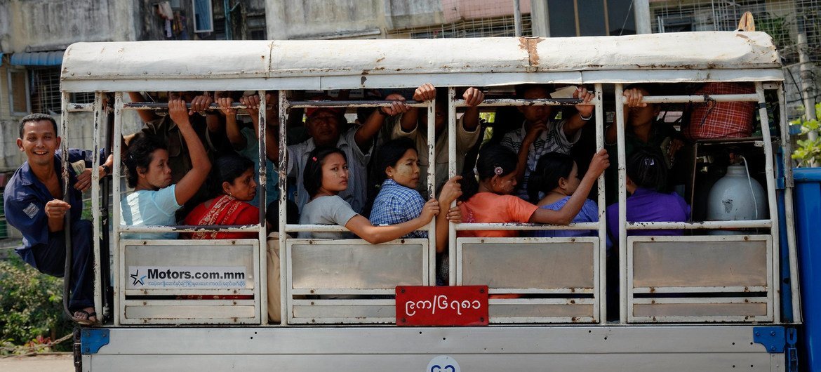 أشخاص يركبون حافلة في يانغون، أكبر مدينة في ميانمار.