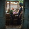म्याँमार के शन प्रान्त में एक महिला अपने घर पर भोजन पकाने से पहले सब्ज़ियाँ धोते हुए. 