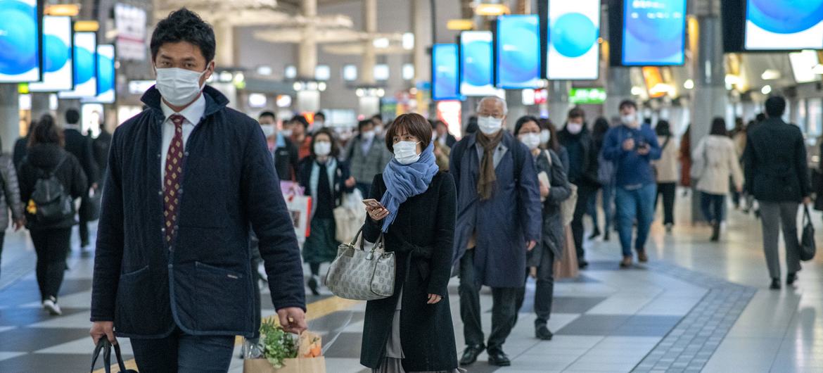 जापान की राजधानी टोक्यो में, कोविड-19 से बचाव के लिये मास्क पहने हुए लोग.